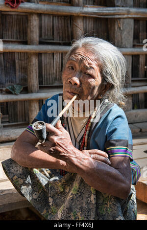 Un Muun mento della donna con la faccia di tatuaggi fumare una tubazione di tutolo di mais, Kyar Daw, Mindat, Foto Stock