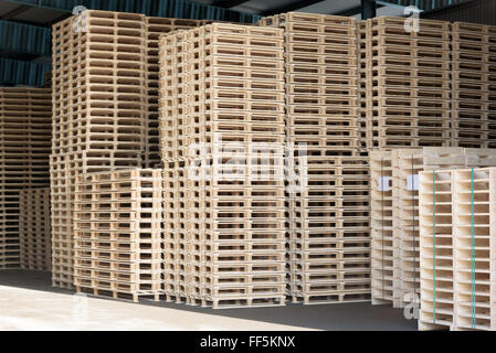 Un sacco di pallet impilati e pronto per l'uso. Queste sono quelle di nuova costruzione in open storage building. Foto Stock