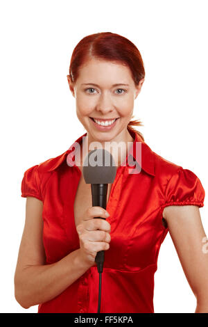 Redhaired sorridente donna reporter tenendo un microfono Foto Stock