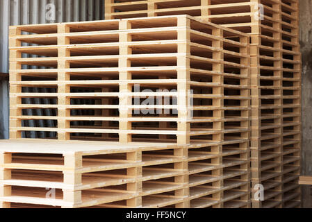 Un sacco di pallet impilati e pronto per l'uso. Queste sono quelle di nuova costruzione in open storage building. Foto Stock