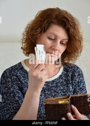 Premurosa donna russa tira dalla sua borsa rubli Foto Stock