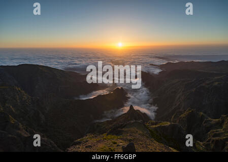 Vista dal Pico do Ariero su alba sulle aspre valli e profondi canyon della costa nord di Madeira coperto di nuvole Foto Stock