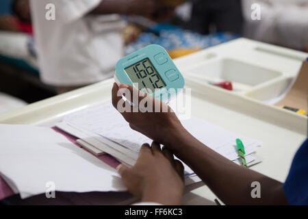 Un medico esaminando un monitor della pressione del sangue, San Francesco Hospital, Tanzania. Foto Stock