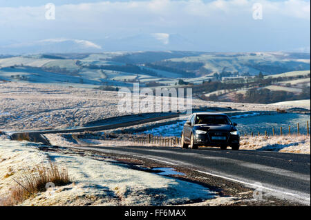 Builth Wells, Powys, Wales, Regno Unito. Xi Febbraio, 2016. Gli automobilisti guida attraverso un gelido paesaggio lungo la B4520 'Brecon Road' in alto la brughiera di Mynydd Epynt intervallo vicino Builth Wells in Powys, Wales, Regno Unito. Credito: Graham M. Lawrence/Alamy Live News. Foto Stock