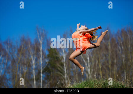 Ginnasta giovani facendo esercizi in una foresta a primavera tempo Foto Stock
