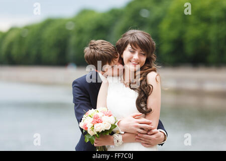 Sposa e lo sposo abbracciando il terrapieno in il vostro giorno di nozze Foto Stock