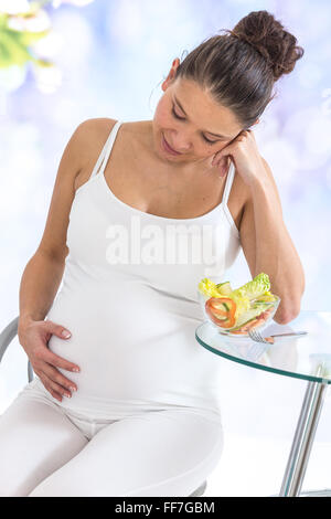 Una sana alimentazione per la gravidanza. Asian della donna incinta, pancia e insalata di verdure Foto Stock