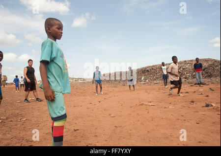 Mali, Africa - nero di persone che giocano a calcio vicino a Bamako in una discarica di rifiuti. Foto Stock