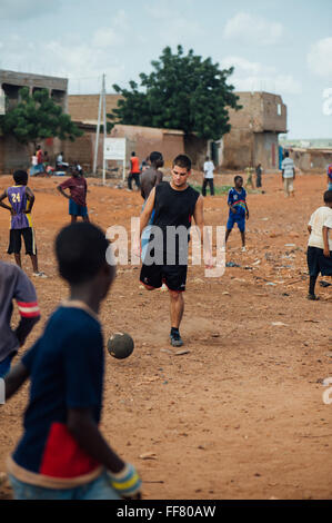 Mali, Africa - In bianco e nero di persone divertirsi giocando a calcio in una discarica per rifiuti Foto Stock