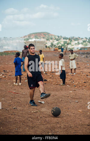 Mali, Africa - In bianco e nero di persone divertirsi giocando a calcio in una discarica per rifiuti Foto Stock