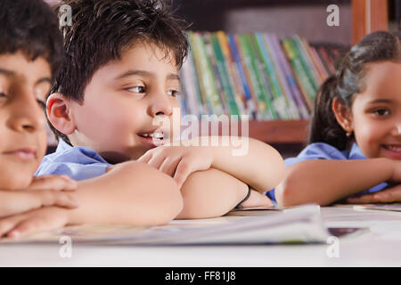 Asia Asian asiatici costumi scaffale Carefree incurante Childs mento sulle mani compagni di scena in Aula le scene in aula Foto Stock