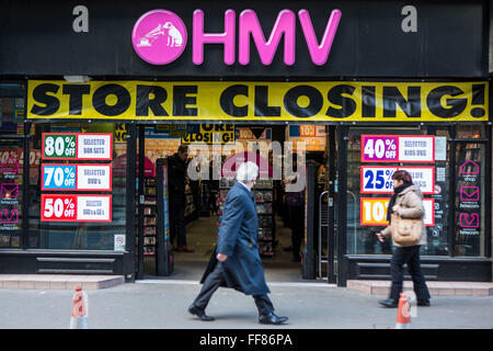 Una città britannica lavoratore passeggiate passato un intrattenimento HMV store retail in Square Mile, nel centro di Londra, Regno Unito. Il negozio è di avere una chiusura di vendita e a causa della recessione economica la vendita al dettaglio britannico azienda è entrata in amministrazione nel gennaio 2013. Foto Stock