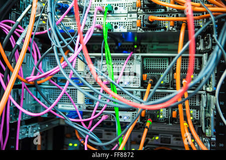 Una grande massa di multi-colore dei cavi del computer in una sala server in un British business office di Londra, Regno Unito. Foto Stock