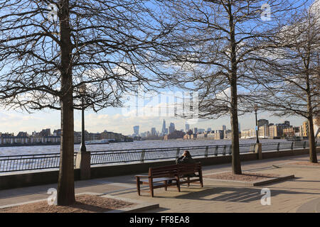 Udienza dal fiume Tamigi in inverno il sole sotto il cielo blu guardando verso la città e Rotherhithe sulla Thames Path Foto Stock