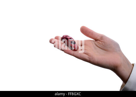 Bambino la mano che regge un auto rossa su uno sfondo bianco Foto Stock