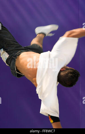 Vista posteriore di un giovane ballerino di break dance con entrambe le gambe all'aria. Foto Stock