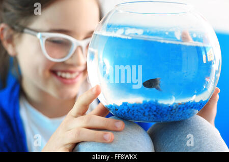 Voglio pet ... . Bambino in possesso di una sfera di cristallo blu con un pesce Foto Stock