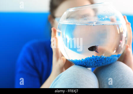 Voglio pet ... . Bambino in possesso di una sfera di cristallo blu con un pesce Foto Stock