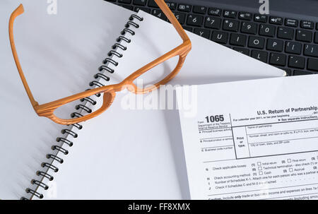 Ufficio tavolo scrivania con computer, eyegglass 1065 taxform su notebook Foto Stock