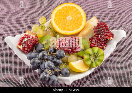 Piastra di colore bianco pieno di diversi tipi di frutta Foto Stock