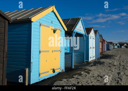 Cabine sulla spiaggia, a West Wittering su un luminoso pomeriggio invernale, West Sussex, in Inghilterra, Regno Unito Foto Stock