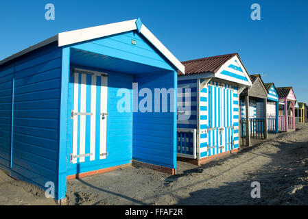 Dipinto luminosamente beach capanne a West Wittering in un assolato pomeriggio invernale, West Sussex, Regno Unito Foto Stock