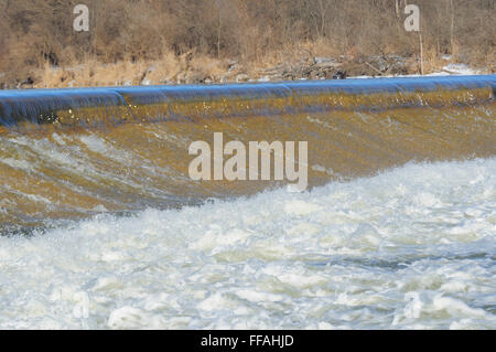 Acqua che scorre sulla diga sul fiume. Foto Stock