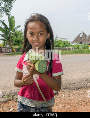 Ragazza giovane la vendita di semi di loto teste, Samatoa Lotus Farm, Sangat Siem Reap, Cambogia Foto Stock