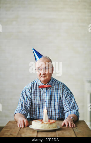 Senior uomo guardando la sua torta di compleanno per il settantesimo  compleanno Foto stock - Alamy