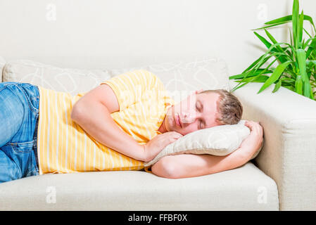 Ritratto di un uomo che dorme sul divano del soggiorno Foto Stock