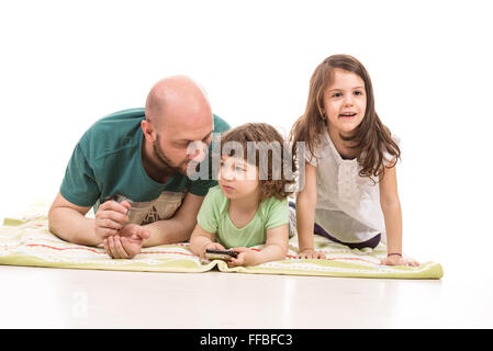 Padre e due bambini seduti sul pavimento home Foto Stock