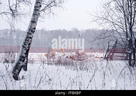 Lavori di costruzione in inverno durante la nevicata Foto Stock