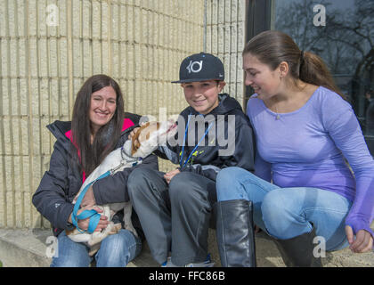 Wantagh, New York, Stati Uniti d'America. 7 febbraio, 2016. Mom SARI, figlio Andrew e figlia Emily, volontari di Merrick, pet Halley il bianco e arancio beagle, chi è disponibile per l'adozione, il Cane affettuoso lambisce Andrew prima della famiglia prende Halley per una passeggiata durante l ultima speranza salvataggio animale Open House durante Hallmark Channel gattino ciotola III. Il centro ha gli ospiti hanno guardato il felino di partite di calcio in TV e rallegrato per il loro team, l'ultima speranza Lions. Oltre 100 adottabile gattini da ultima speranza Inc e North Shore Animal League America ha partecipato ai Giochi per il campionato 2016, whi Foto Stock