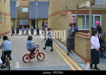 Ebrea ortodossa di bambini che giocano in strada di Reizel chiudere un Agudas Israele Housing Association per lo sviluppo a basso reddito ebrea ortodossa le famiglie a Stamford Hill, Londra. Tutti i bambini di giocare insieme regolarmente, avente le corse in bicicletta e giocare a calcio. Vi è un senso reale di una comunità, alcune madri sono fuori con i loro bambini più piccoli mantenendo un occhio sulle vicende riguardanti. Foto Stock