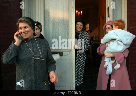 3 generazioni di donne provenienti dalla stessa famiglia guarda il Purim eventi da una distanza di sicurezza. Purim è uno dei più divertenti vacanze ebraiche. Essa commemora il tempo quando il popolo ebraico vive in Persia furono salvati dallo sterminio da un massacro da Haman grazie al coraggio di una giovane donna ebrea chiamato Ester. È consuetudine per gli uomini dress up e di tenere il carnevale-come celebrazioni cantando, ballando e ubriacarsi. Foto Stock