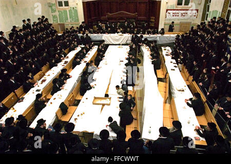 La Chiesa Ortodossa di festa ebraica di Tu Bishvat è celebrato come il nuovo anno di alberi con una simbolica mangiare di diverse varietà di frutta. Qui in Skver East bank sinagoga Stamford Hill il Chassidic Skver Rebbe visita da New York benedice i frutti di fronte a tutta la sinagoga. Foto Stock