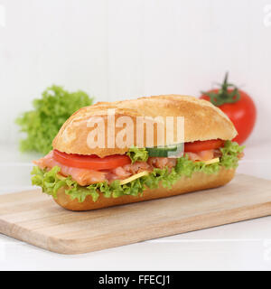 Mangiare sano sub deli sandwich baguette con salmone pesce, formaggio, pomodori e lattuga per la prima colazione Foto Stock