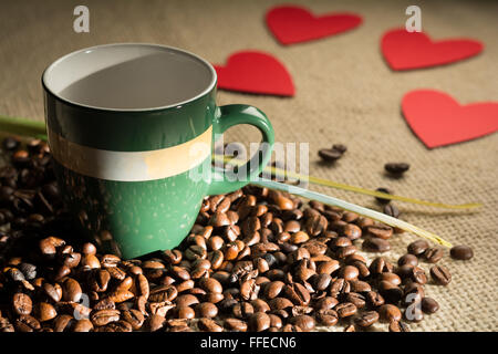 Tazza di caffè con fagioli e cuori sparsi in carta Foto Stock