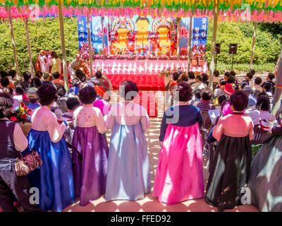 Un gruppo di donne coreane in abito tradizionale attendere per dare loro offerte a un Buddha la celebrazione di compleanno. Foto Stock