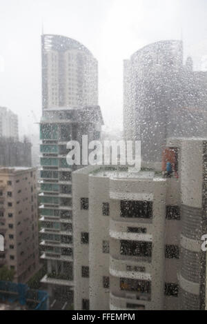 Edifici di appartamenti nel centro di Singapore durante forti piogge stagionali. Foto Stock