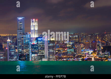 Centro di quartiere finanziario centrale di notte vista dalla piscina Infinity della Marina Bay Sands Hotel, Singapore Foto Stock