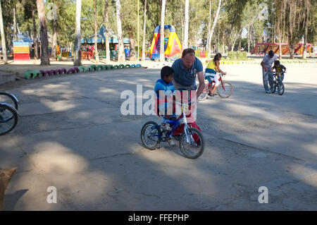 Cochabamba Bolivia. Caucasica padre maturo come insegnamento per bike il suo latino adottato il ragazzo Foto Stock