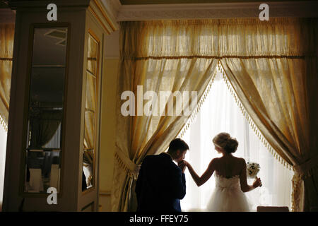 Sposa e lo sposo in piedi nella parte anteriore della finestra Foto Stock