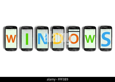 Windows scritto su schermi di smartphone fotografati contro uno sfondo bianco. Foto Stock