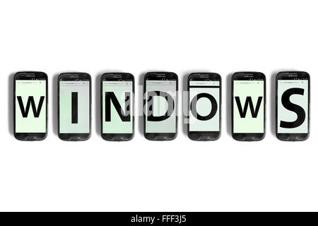 Windows scritto su schermi di smartphone fotografati contro uno sfondo bianco. Foto Stock