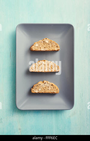 I Cantucci sul quadrato piatto grigio e blu nella tabella. Tipiche italiane i cookie Foto Stock