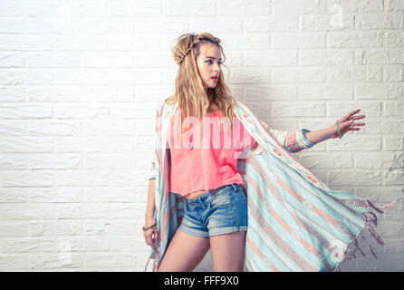 Boho Moda ragazza al bianco muro di mattoni in background Foto Stock