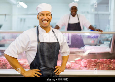 Sorridente macelleria maschio proprietario del negozio Foto Stock