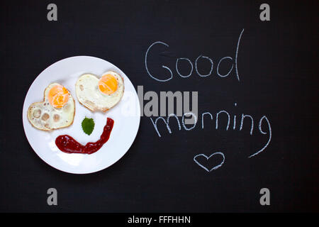 La prima colazione, uova fritte in forma di cuori, Smile, buon umore, mattino luminoso, sfondo Foto Stock