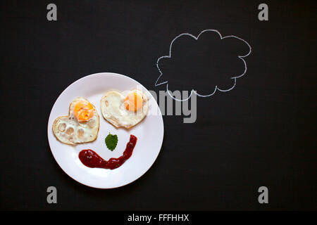 La prima colazione, uova fritte in forma di cuori, Smile, buon umore, mattino luminoso, sfondo Foto Stock